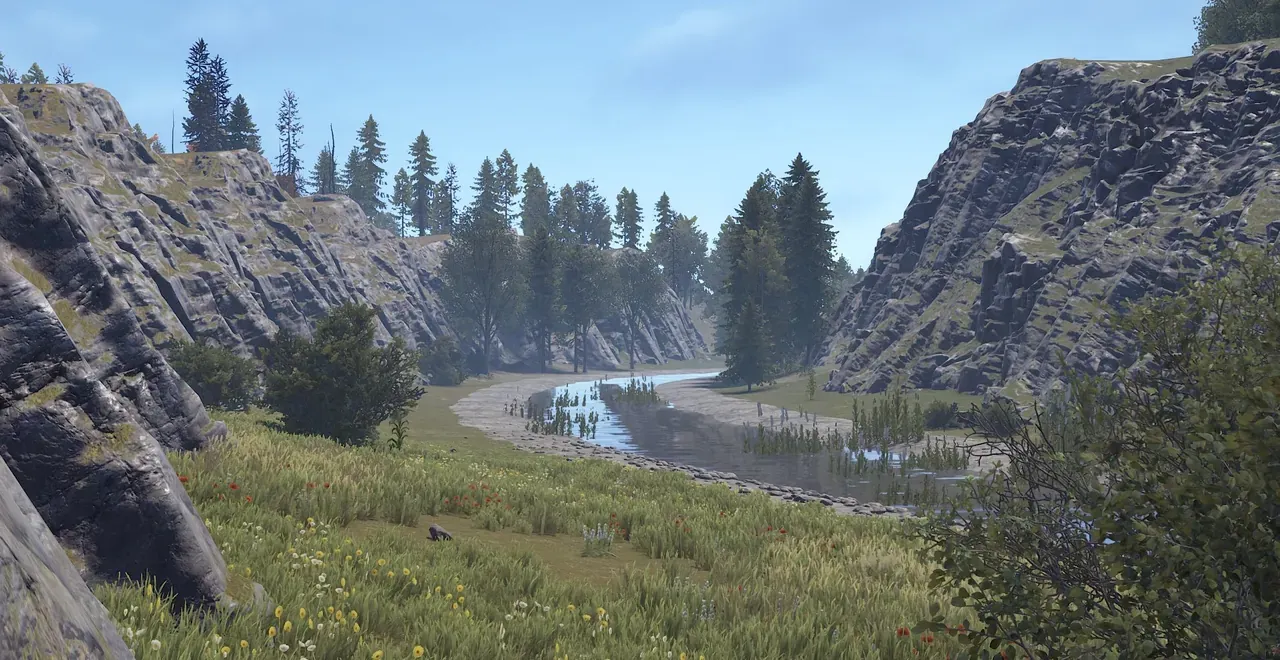 In-game view of a custom Rust map on Crucible terrain: a grassy canyon with a river and pine trees between rock cliffs